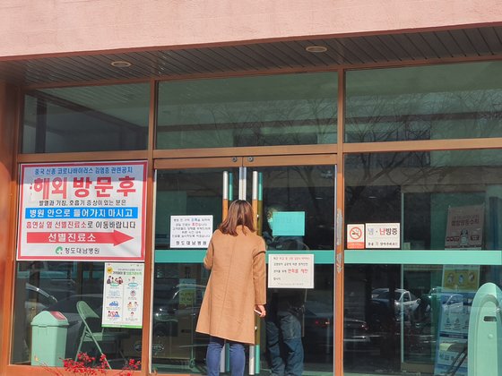 ２０日、慶尚北道清道郡清道テナム病院を訪れた訪問者が堅く閉じられたドアの隙間から病院関係者と話している。チン・チャンイル記者