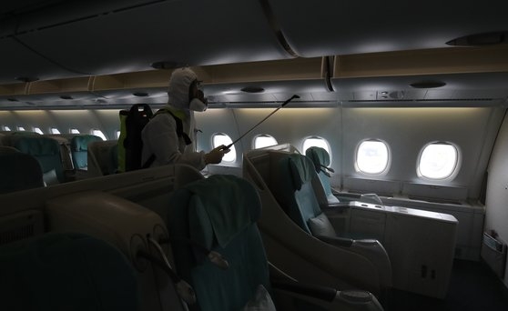 ４日午後、仁川国際空港で防疫会社の職員がニューヨーク行き大韓航空機の消毒作業をしている。　キム・ソンリョン記者