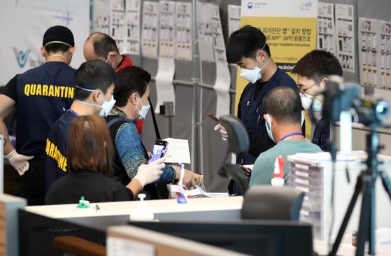 韓日両国間の相互ノービザ入国が中断した９日、仁川国際空港第２ターミナルで日本発旅客機に乗って到着した乗客が検疫と連絡先確認など特別入国手続きを踏んでいる。　キム・ソンリョン記者
