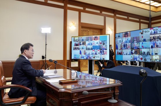 文在寅大統領が２６日、青瓦台執務室で分割された大型モニター画面に登場したＧ２０首脳らを見ながら「Ｇ２０特別テレビ首脳会議」に参加している。［写真　青瓦台写真記者団］