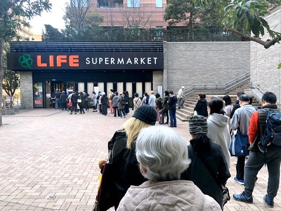２５日午前、東京目黒区のあるスーパーマーケットの前に食料品を買おうとする市民が長い列をつくっている。ソ・スンウク特派員