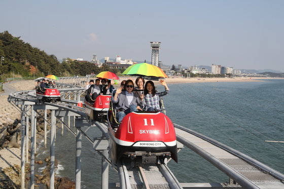 観光客が大川海水浴場の海上に設置されたスカイバイクを楽しんでいる。大川海水浴場の北側から大川港まで海岸線の往復２．３キロメートル区間を往復する。［中央フォト］