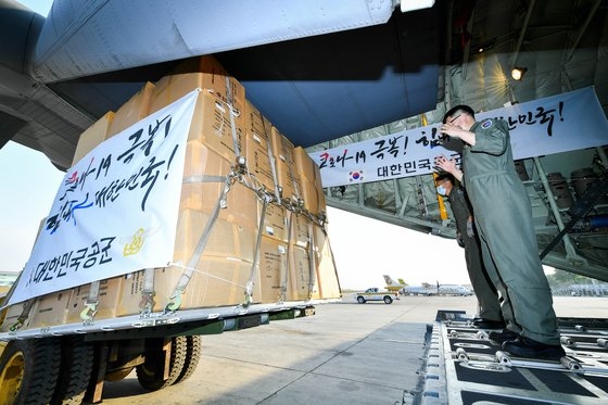 韓国空軍第５空中機動飛行団の将兵が３月１８日（現地時間）、ミャンマー・ヤンゴン国際空港で防疫物資をＣ－１３０Ｊ輸送機に積み込んでいる。［写真　空軍］