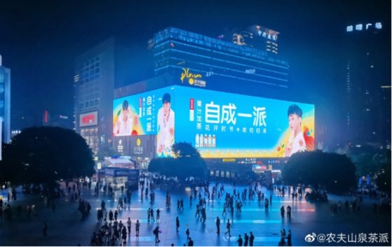 ＢＩＧＢＡＮＧのＧ－ＤＲＡＧＯＮが出ている中国飲料「茶パイ」の広告。重慶市の大型ショッピングモールのＬＥＤ電光掲示板に登場した。［写真　中国飲料メーカー農夫山泉の微博］