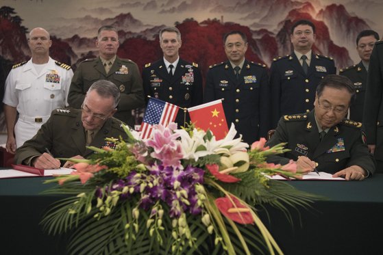 ２０１７年８月、北京でダンフォード米統合参謀本部議長（左）と房峰輝・中国人民解放軍総参謀長がお互いの判断の過ちを防ぐ対話チャンネル開設合意書に署名している。［米合統合参謀本部ウェブサイト］
