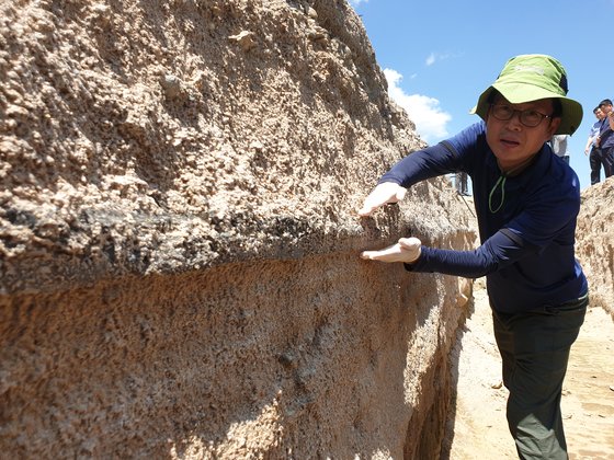 緑色連合のソ・ジェチョル専門委員が文化財発掘作業中の旧米軍基地キャンプページの発掘現場で出た廃アスコンについて説明している。パク・ジンホ記者