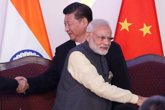 ２０１６年１０月にインドのゴアで開かれたＢＲＩＣｓ首脳会談で中国の習近平国家主席（左）とインドのモディ首相（右）が握手を終え通り過ぎている。［中央フォト］