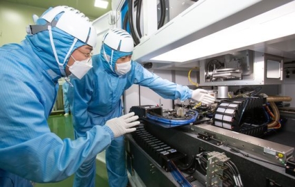サムスン電子とＥＯテクニクスの職員が、２社が共同開発した半導体レーザー装置を一緒に見ている。［写真　サムスン電子］