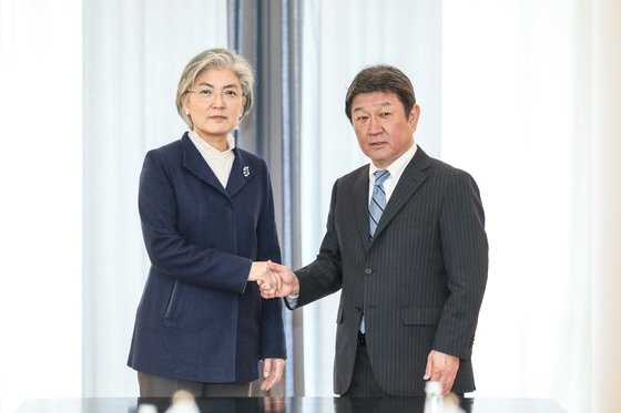 今年２月のミュンヘン安保会議に出席した韓国の康京和（カン・ギョンファ）外交部長官（左）が、日本の茂木敏充外相（右）と韓日外相会談に先立ち握手をしている。［写真　韓国外交部］