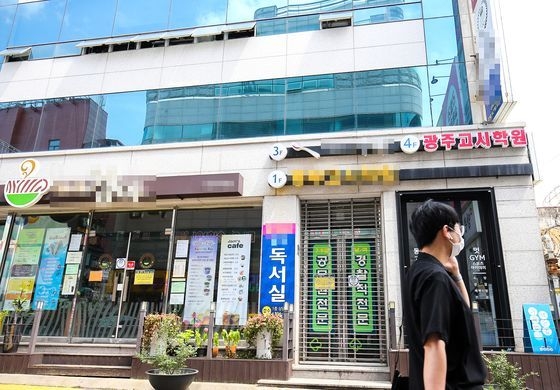 新型コロナウイルス感染者が発生して閉鎖された光州東区の光州考試学院前を人々が通り過ぎている。［写真　チャン・ジョンピル］