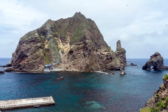 独島（ドクト、日本名・竹島）は東島と西島、そして約８９の岩と暗礁で形成されている。東島の頂上から見下ろした船着き場と西島の様子。右側に見える岩は三兄弟窟岩だ。中央フォト