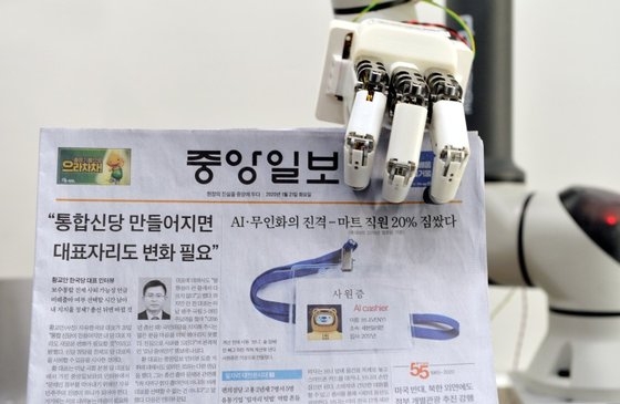 韓国機械研究院のト・ヒョンミン博士研究チームが１月に大田の韓国機械研究院先端生産装備研究本部ロボットメカトロニクス研究室で人間型ロボットの手で中央日報をつかんで見せている。［中央フォト］