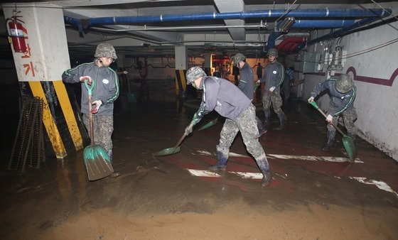 ２０１６年１０月９日、台風１８号の影響で被害が発生した慶尚南道梁山のマンションの地下駐車場で住民と公務員、軍人が復旧作業をしている。　中央フォト