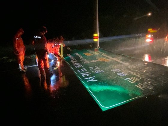 ７日午前４時ごろ、台風１０号の影響で済州市旧左邑（チェジュシ・クジャウプ）のある道路にあった道路表示板が落ちて消防署員が安全措置を取っている。［写真　済州道消防安全本部］