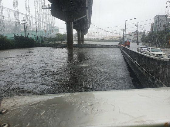 ７日午前９時、釜山東区東川一帯の水位が高くなって氾濫の危機が迫っている。［写真　釜山警察庁］