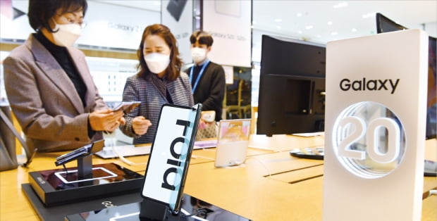 ４月７日、ソウル・瑞草洞社屋にあるサムスン電子の製品体験展示場「ディライトショップ」で消費者がスマートフォンを見ている。カン・ウング記者