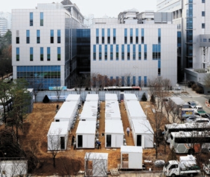 １１日、新型コロナ専門病院のソウル医療院の空き地で１６個のコンテナ病棟設置作業が行われている。この日の新規感染者は６８９人と、２月２９日（９０９人）以降で最多となった。ソウル市は２０日までに「コンテナ病床」１５０個を設置する計画だ。