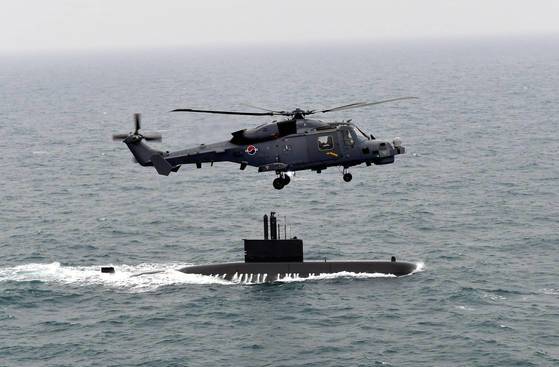 海上作戦ヘリコプター「ワイルドキャット」（ＡＷ－１５９）が海軍潜水艦と海上作戦をしている。　［海軍提供］