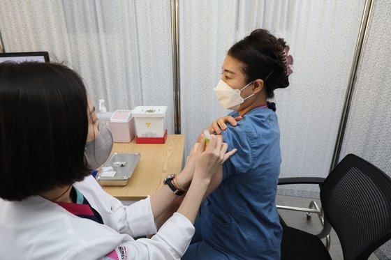 ２７日午前、ソウルの国立中央医療院中央予防接種センターで医療陣がファイザーのワクチンの接種を受けている。［写真　写真記者協会］