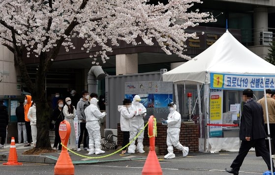 桜が満開した２８日、大田（テジョン）西区保健所を訪れた市民が新型コロナ検査を受けるため列に並んでいる。