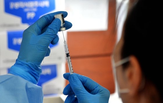 医療陣が高齢者に接種するファイザー製ワクチンを専用注射器に慎重に移している。フリーランサー　キム・ソンテ