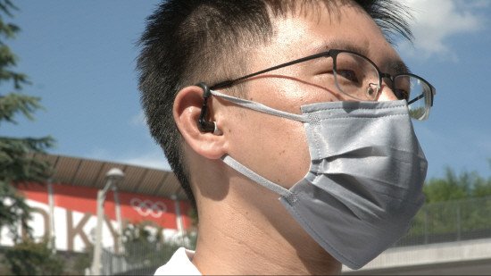 東京オリンピック（五輪）現場職員が知能型イヤーウエアを着用した様子。体温や脈拍数などを基にに熱中病の危険水準を知らせてくれる。［写真　アリババ］
