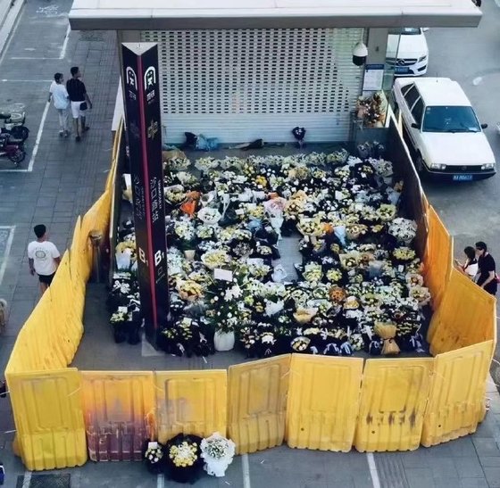２０日、大雨が降った中国河南省鄭州市の５号線地下鉄で乗客１４人が亡くなる惨事が発生した。鄭州市住民たちが故人を悼む「初七日」を迎え、２６日地下鉄駅に追悼の花束を置くと、中国当局が仕切りを設置した。［微博　キャプチャー］