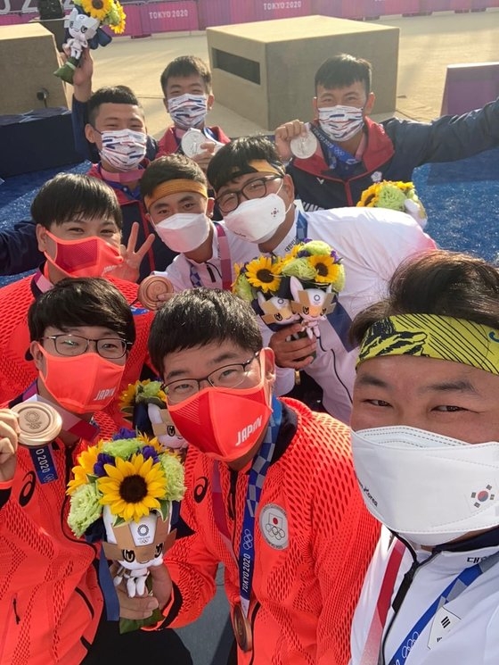 ２６日、東京オリンピック（五輪）男子アーチェリー団体戦で優勝した韓国代表選手たちが夢の島公園アーチェリー場の授賞台で銀メダルの台湾選手、銅メダルの日本選手たちと一緒に記念撮影をしている。［写真　アジアアーチェリー協会　フェイスブック　キャプチャー］