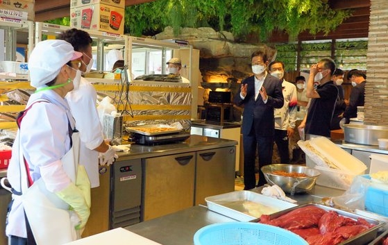 黄熙（ファン・ヒ）文化体育観光部長官が先月２４日、東京の変なホテルに用意された代表チームの給食支援センターを訪問して勤務者を激励している。［写真　在日韓国文化院］