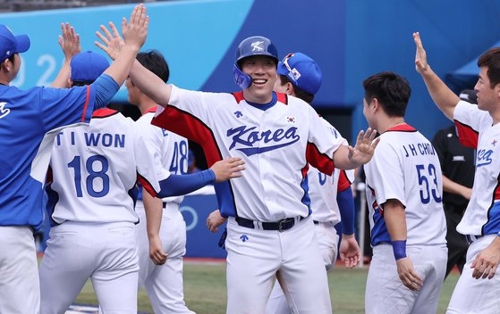 ２日、横浜スタジアムで行われたイスラエル戦で１１－１と７回コールド勝ちし、チームメートと勝利を祝う金賢洙（キム・ヒョンス）。　［横浜＝五輪写真共同取材団］