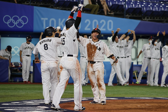 ４日、神奈川県横浜スタジアムで２０２０東京オリンピック（五輪）野球の韓国対日本の準決勝が行われた。八回裏の得点時、日本の選手たちが歓喜している。［写真　横浜＝オリンピック写真共同取材団］