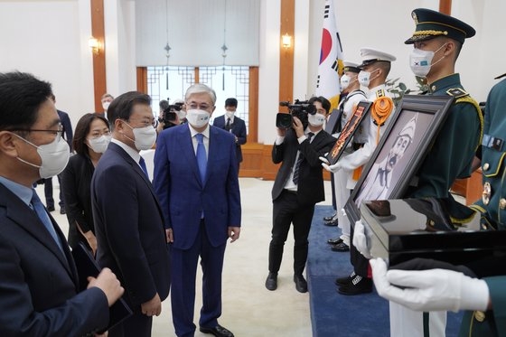 文在寅大統領が１７日に青瓦台で開かれた洪範図将軍の勲章追叙式でカザフスタンのトカエフ大統領と洪範図将軍の肖像を見て対話している。青瓦台写真記者団