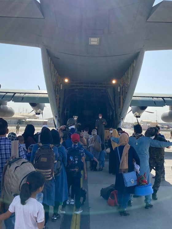韓国政府の活動をサポートしてきたアフガニスタン現地人の職員とその家族の計３９１人が２５日（現地時間）、カブール空港から中間寄着地パキスタン・イスラマバード空港に移動するために空軍輸送機に搭乗している。　［写真　外交部］