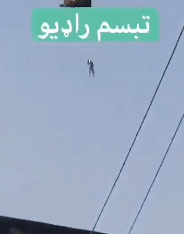 正体不明の人物がヘリコプターに吊るされている（映像　タリブタイムス）