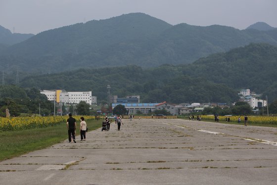 堤川飛行場の滑走路に沿って市民が散歩を楽しんでいる。滑走路の地面が老朽化し、亀裂が生じている。［写真　読者提供］