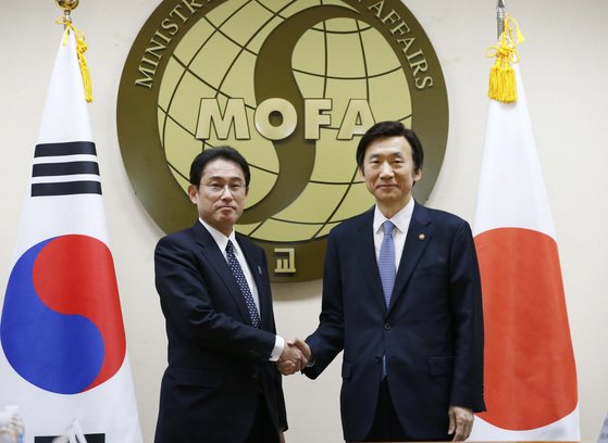 ２０１６年１２月２８日、ソウル外交部庁舎で韓国の尹炳世（ユン・ビョンセ）当時外交部長官（右）と岸田文雄当時外相が慰安婦問題解決方案を探る会談に先立ち握手をしている。［写真　共同取材団］