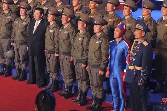 北朝鮮の金正恩（キム・ジョンウン）国務委員長が１１日、国防発展展覧会開幕式でエアショーを行ったパイロットとともに記念写真を撮影している。前列右側から２番目に立っている人物は青色の独特の服装をしている。［写真　朝鮮中央通信＝聯合ニュース］