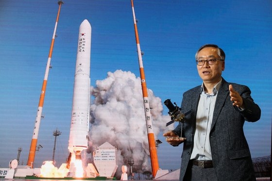 申鉉宇（シン・ヒョンウ）ハンファエアロスペース代表が２０１８年、羅老（ナロ）宇宙センターで打ち上げられた「ヌリ」試験ロケットの写真を背景に立っている。　［中央フォト］