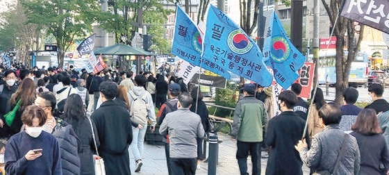 ２３日のソウル江南（カンナム）駅付近。「４・１５不正選挙真相究明」などの旗を掲げた中高年者が若者の間で行進している。　キム・ソンタク／論説委員