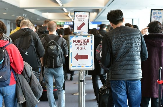 新型コロナウイルスのオミクロン株が世界に急速に広がる中、２９日にハバロフスクとフランクフルトからの入国者らが仁川国際空港に入国して審査を受けている。［写真　空港写真記者団］