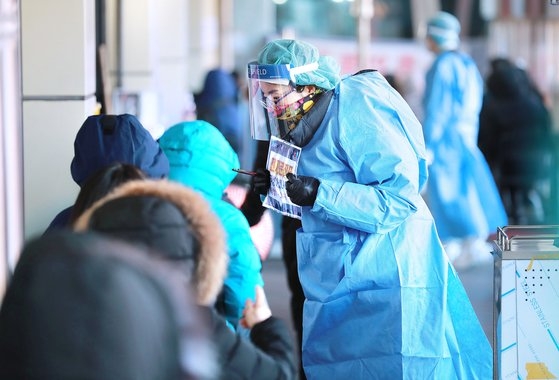 １日午前、ソウル市の松坡保健所の新型コロナウイルス選別診療所で医療陣が寒さに備えて防寒着を中に着て市民を案内している。［中央フォト］