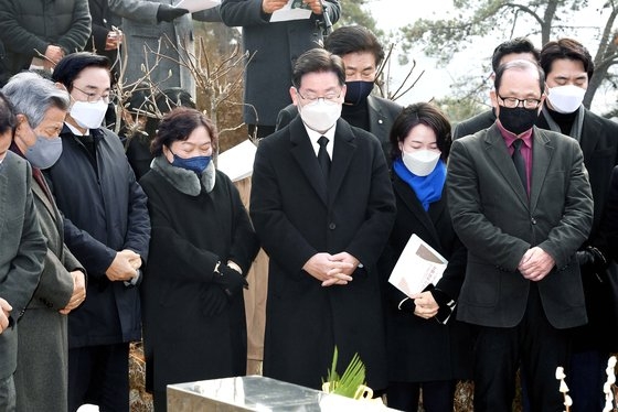 共に民主党の李在明（イ・ジェミョン）大統領候補（中）が２９日、京畿道南揚州市の牡丹公園で行われた故金槿泰（キム・グンテ）元開かれたウリ党議長１０周忌追悼行事で黙祷している。李候補はこの日、「議長が実現させようとした世の中と、私、李在明が実現させようという世の中は全く変わらない」と述べた。　［国会　写真記者団］