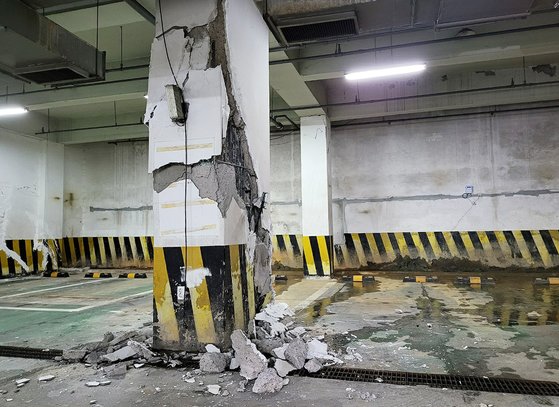 地盤沈下により破損した地下駐車場の柱。［写真　ニュース１］