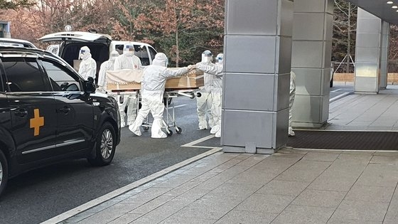 昨年１２月、京畿道（キョンギド）のある火葬場でレベルＤ防護服を着た職員が新型コロナ感染による死亡者の棺を運んでいる。　［韓国葬儀協会提供］