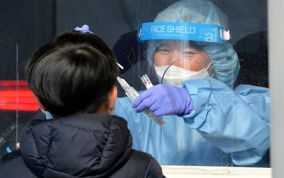 韓国で新型コロナウイルス感染症（新型コロナ）発生２年目となった今月２０日、大田（テジョン）のある保健所選別診療所で医療スタッフが訪問した市民を慎重に検査している。キム・ソンテ