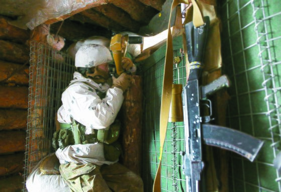 塹壕の中から外部を観察中のウクライナ軍人。［写真　ＡＦＰ＝聯合通信］