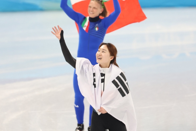 １６日午後、北京首都体育館で開かれた２０２２北京冬季オリンピック（五輪）ショートトラック女子１５００メートルで金メダルを獲得した韓国の崔ミン禎（チェ・ミンジョン）が太極旗を体にまとって観客席に向かって挨拶をしている。［写真　キム・ギョンロク記者］