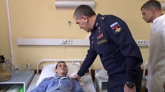 ロシア国防省のユヌス＝ベク・エヴクロフ戦闘教育次官は２６日、両足を失う負傷を負ってベッドに横になっているロシア兵士のお見舞いのために病院を訪問した。エヴクロフ次官が「私は必ずあなたがもう一度自ら歩くことができるように願う」と言うと、兵士は多少ぼんやりとした顔で見つめている。［ツイッター　キャプチャー］