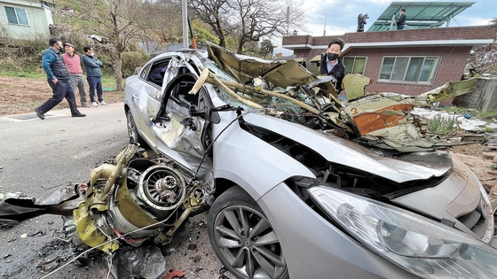 １日、慶南泗川（サチョン）で空軍基本訓練機ＫＴ－１が訓練飛行中に衝突し、操縦士ら４人が殉職した。この日、住宅街に落ちた訓練機の残骸を住民が見ている。　ソン・ボングン記者