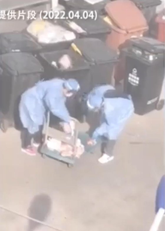 今月４日、上海で防疫服を着た職員が長期間放置されて腐った肉を捨てている。住民が撮影してＳＮＳに投稿した。［写真　微博　キャプチャー］